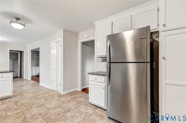 a kitchen with granite countertop white cabinets white stainless steel appliances and granite counter tops