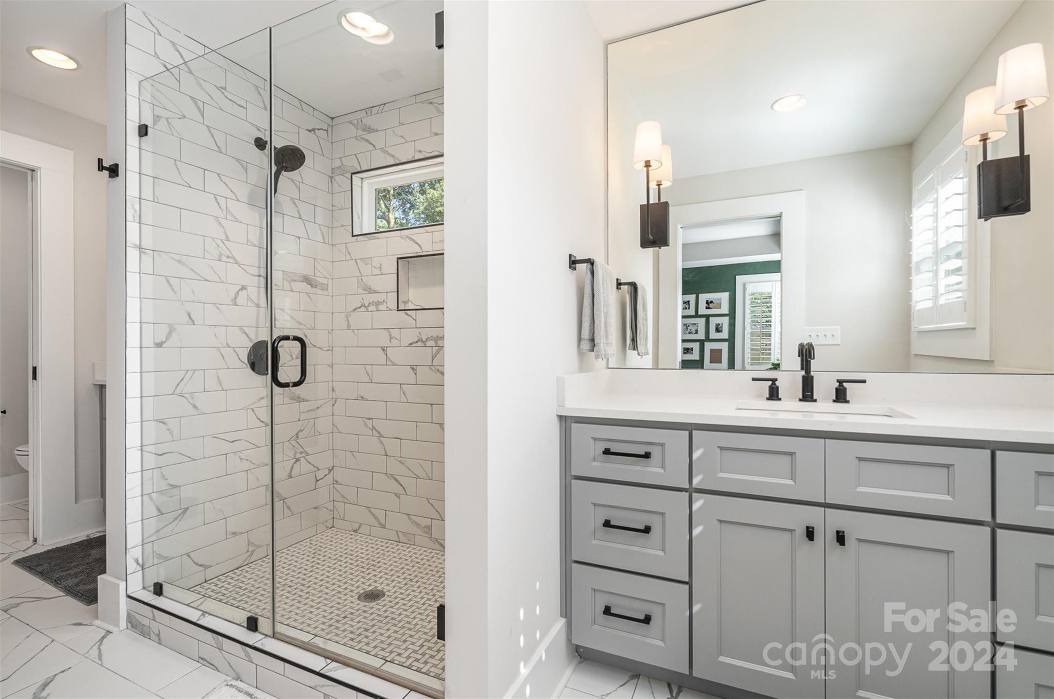 5335 Valley Forge Road Charlotte, NC 28210 - Photo 17 of 29 a bathroom with a shower sink and mirror