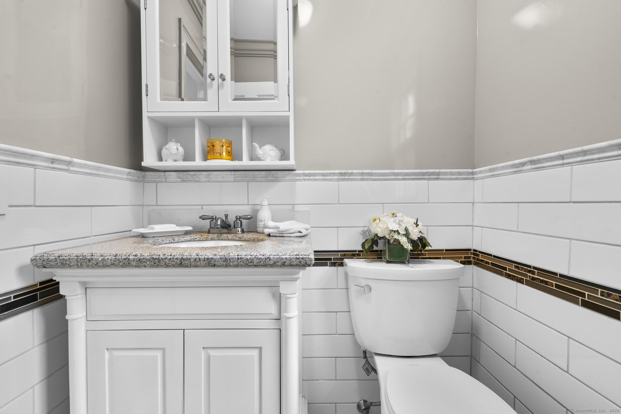 14 East Gate Road Danbury, CT 06811 - Photo 23 of 40 a bathroom with a granite countertop toilet sink and mirror