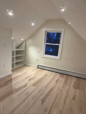 an empty room with a wooden floor and a window