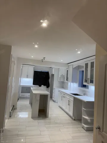 a kitchen with a sink and a stove top oven with wooden floor