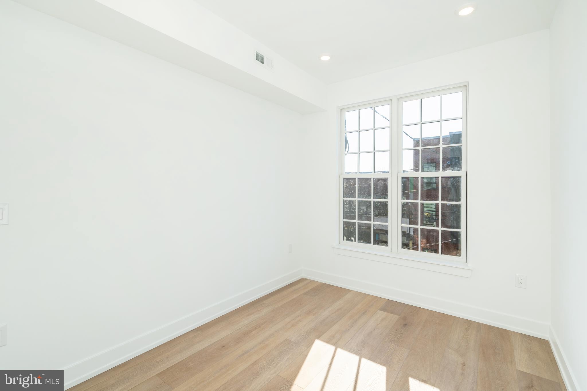 2002 Frankford Avenue, Unit 202 Philadelphia, PA 19125 - Photo 12 of 20 an empty room with wooden floor and windows