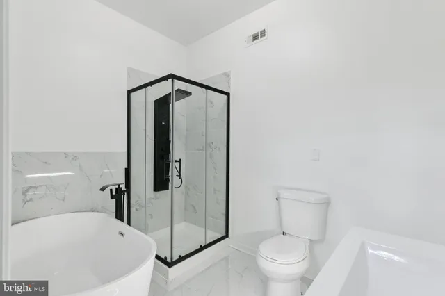 a bathroom with a white bath tub and shower
