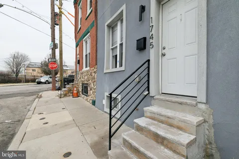 a view of a room with wooden floor and a bathroom