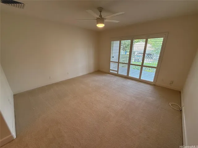 an empty room with windows and ceiling fan