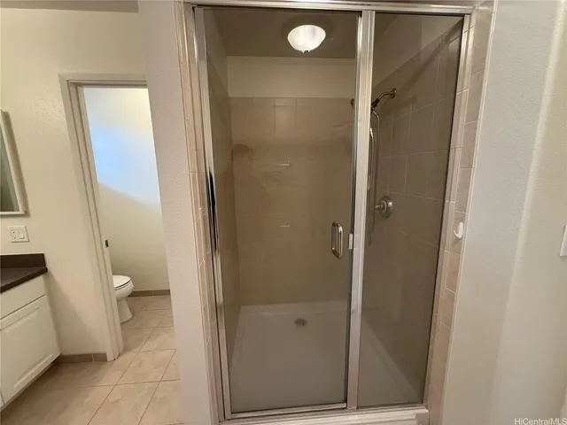 a bathroom with a granite countertop shower and a toilet