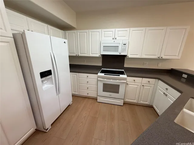 a kitchen with white cabinets and white appliances