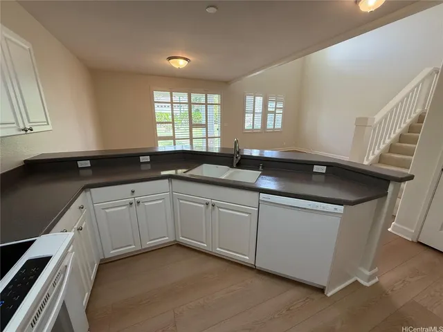a kitchen with granite countertop a sink and white cabinets