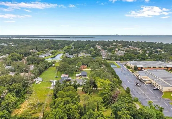 an aerial view of residential houses with outdoor space and trees