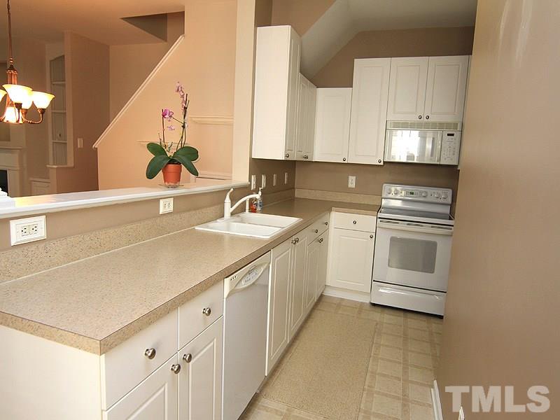 2328 Persimmon Ridge Drive Raleigh, NC 27604 - Photo 4 of 12 a kitchen with white cabinets and white appliances