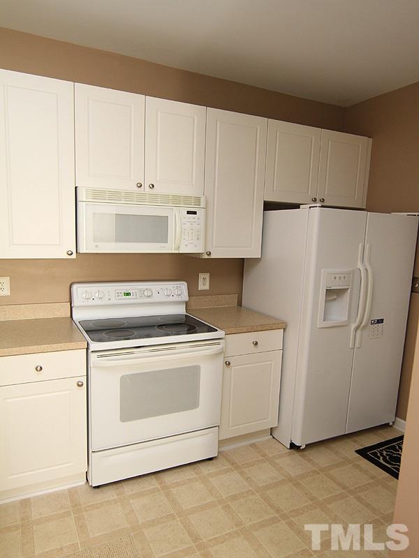 2328 Persimmon Ridge Drive Raleigh, NC 27604 - Photo 5 of 12 a kitchen with white cabinets and white appliances