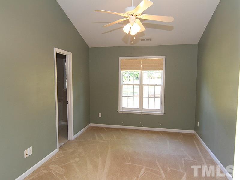 2328 Persimmon Ridge Drive Raleigh, NC 27604 - Photo 8 of 12 an empty room with a chandelier fan and windows