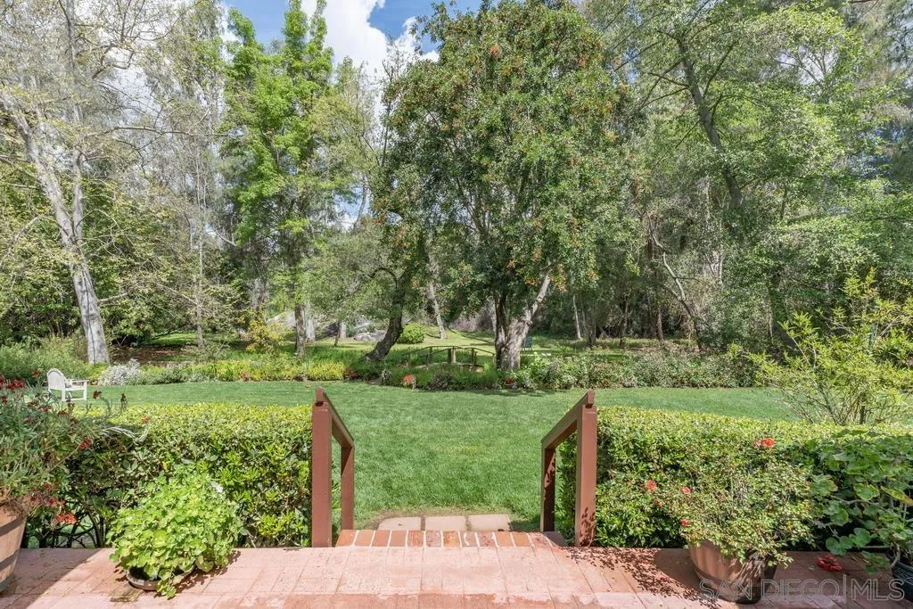 13636 Jack Rabbit Road Poway, CA 92064 - Photo 3 of 29 a view of a garden with a bench and trees