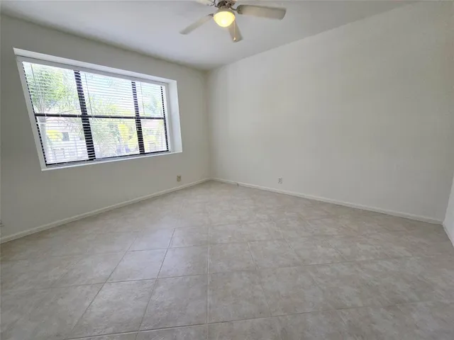 an empty room with window and carpet