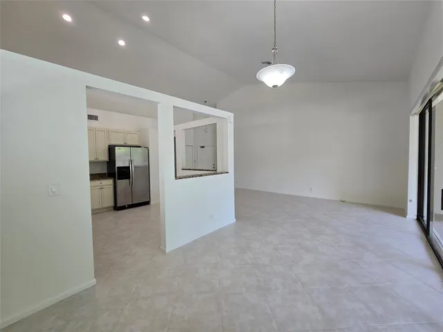 a view of empty room with wooden floor and ceiling fan