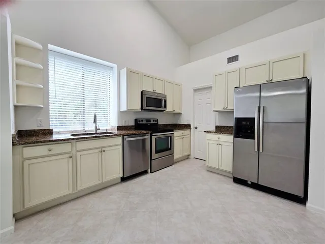 a kitchen with a refrigerator stove microwave and sink