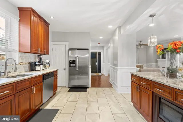 a large kitchen with stainless steel appliances granite countertop a sink and cabinets