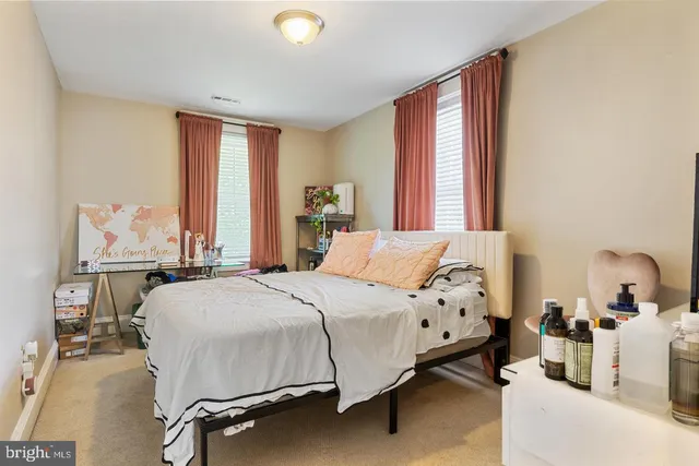 a bedroom with a bed and large windows