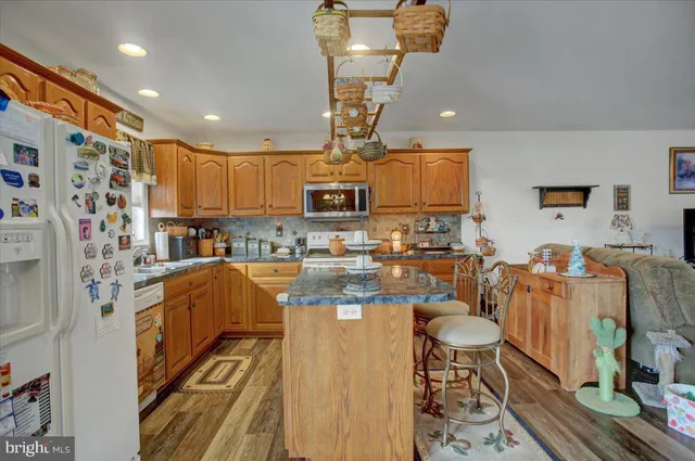 a kitchen with stainless steel appliances granite countertop a sink dishwasher a refrigerator a microwave oven with granite countertops and cabinets