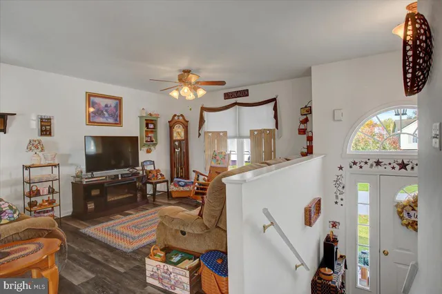 a living room with furniture a flat screen tv and a large window