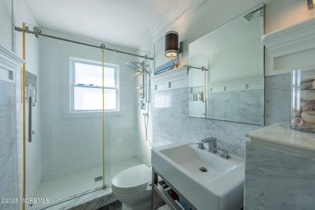 a bathroom with a sink mirror toilet and shower