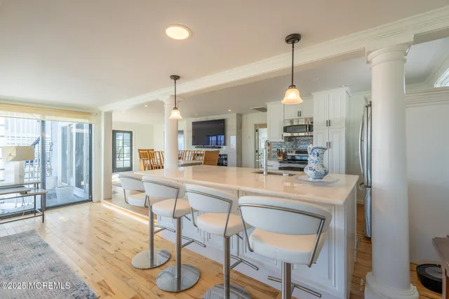 a view of a dining room and livingroom with furniture wooden floor a chandelier