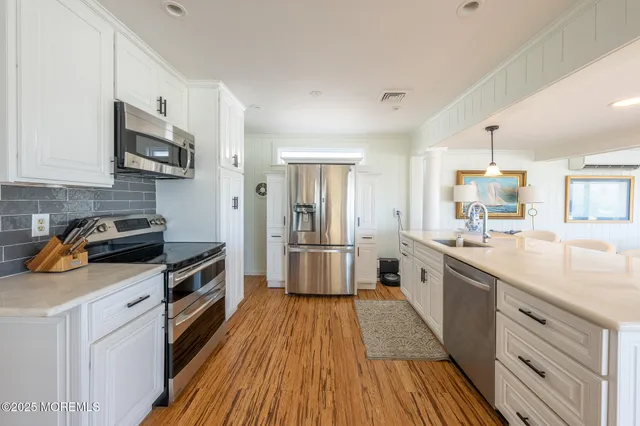 a kitchen with stainless steel appliances a stove sink microwave and cabinets