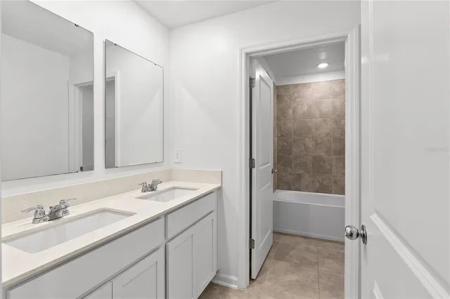 a bathroom with a tub sink shower and a mirror