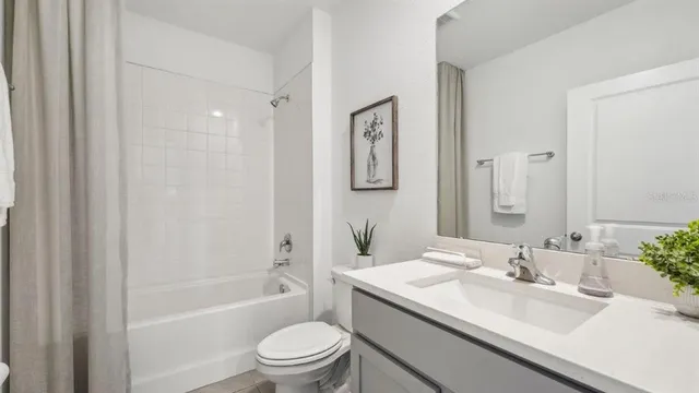 a bathroom with a granite countertop sink a toilet and shower