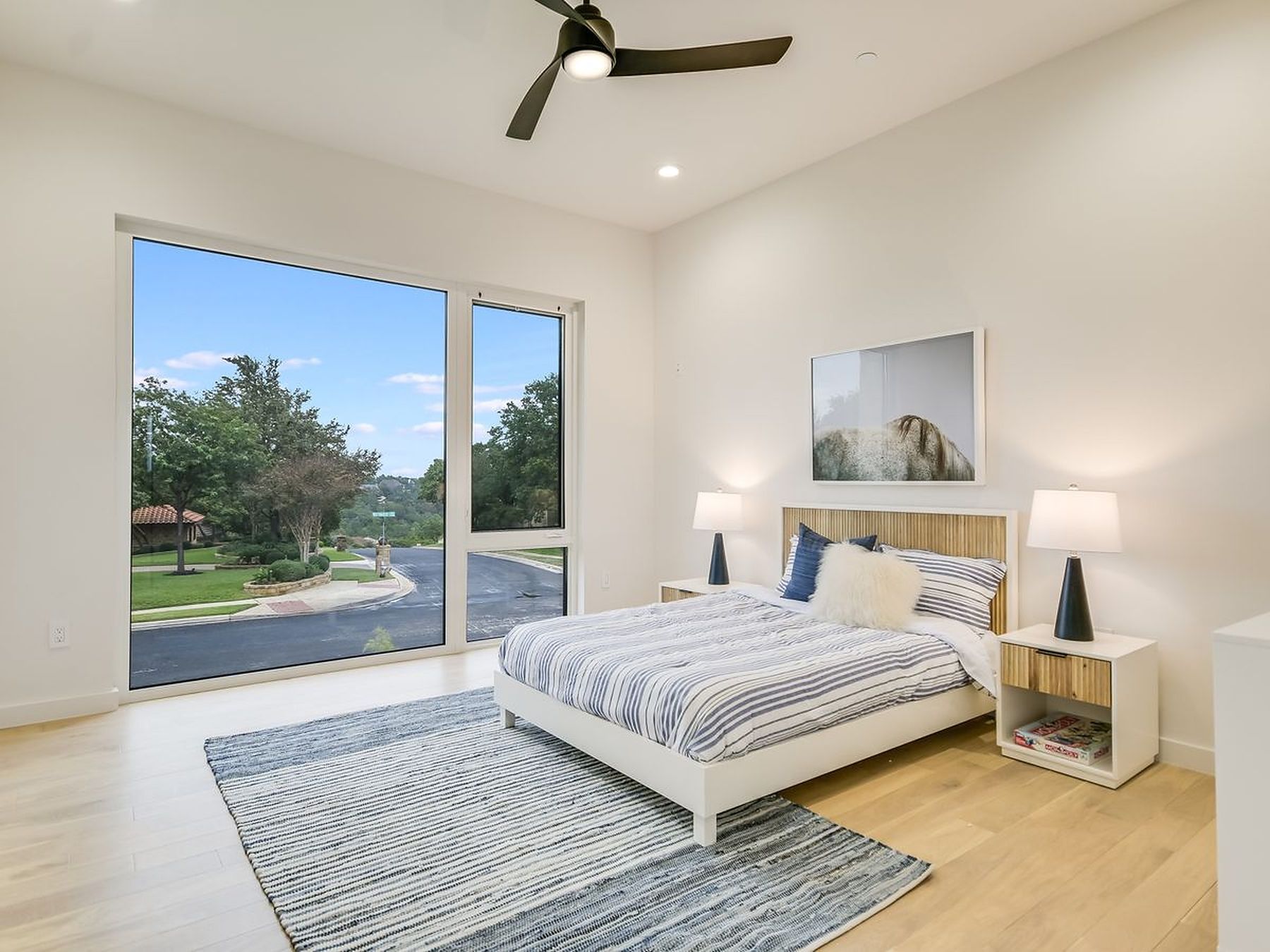 2476 Waymaker Way Austin, TX 78746 - Photo 20 of 31 A tranquil sleeping space boasts tall windows, offering scenic street and nature views.