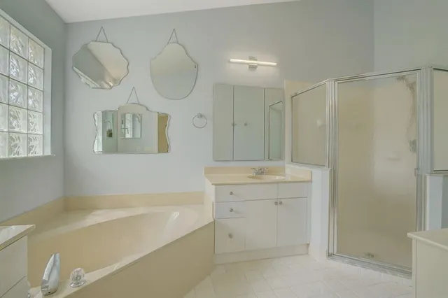 a bathroom with a tub sink and mirror