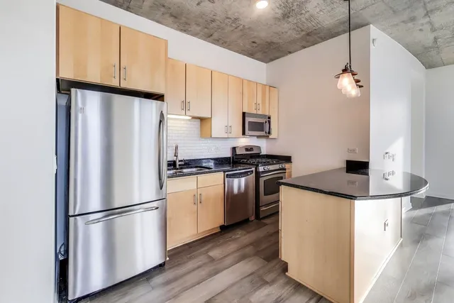 a kitchen with appliances a refrigerator and cabinets