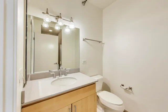 a bathroom with a granite countertop sink toilet a large mirror and shower
