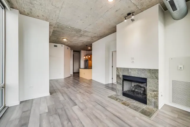a view of a livingroom with wooden floor and a fireplace