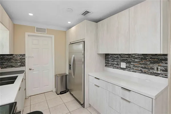 a kitchen with a refrigerator and a stove top oven
