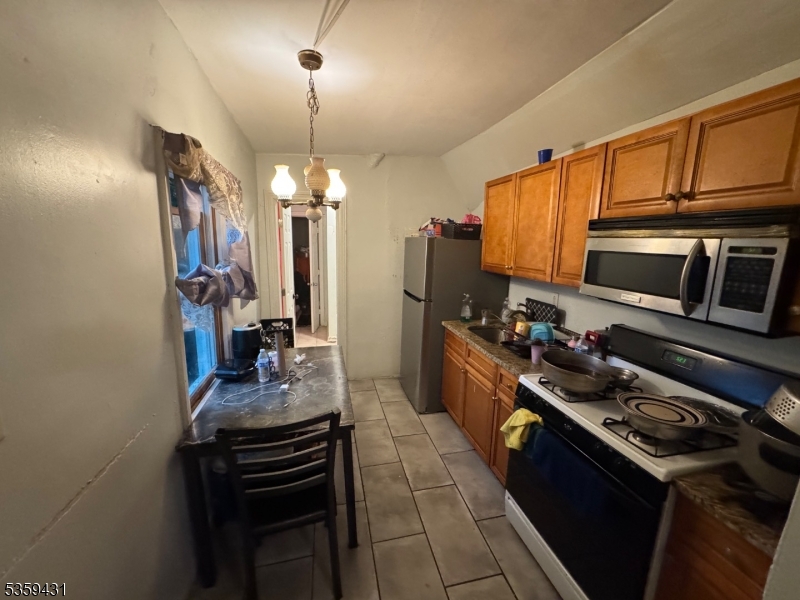 57 East Main Street Paterson, NJ 07522 - Photo 7 of 20 a kitchen with stainless steel appliances a stove sink microwave and cabinets