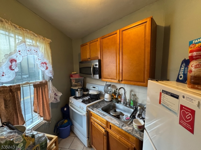57 East Main Street Paterson, NJ 07522 - Photo 10 of 20 a kitchen with stainless steel appliances granite countertop a stove a sink a refrigerator and a microwave