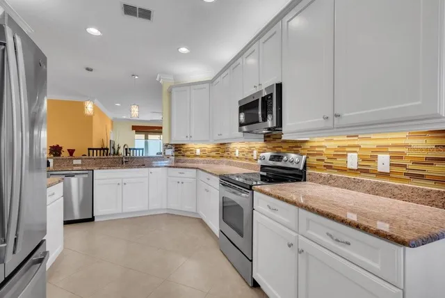 a kitchen with granite countertop a sink stainless steel appliances and cabinets