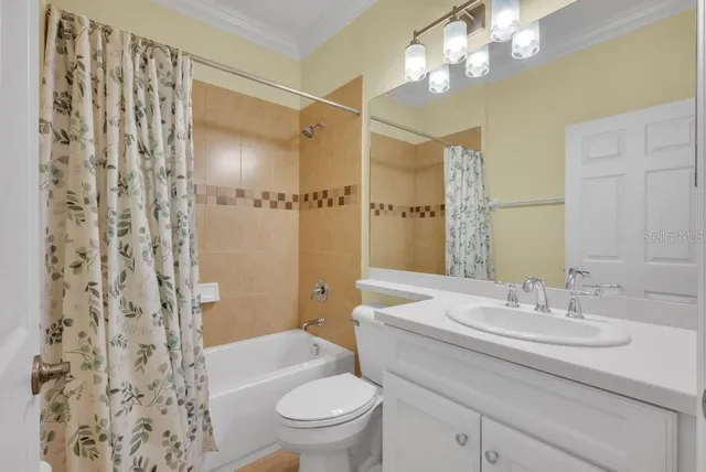 a bathroom with a sink a toilet a mirror a vanity and shower