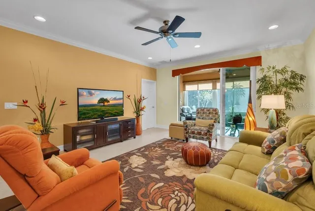 a living room with furniture a flat screen tv and a large window