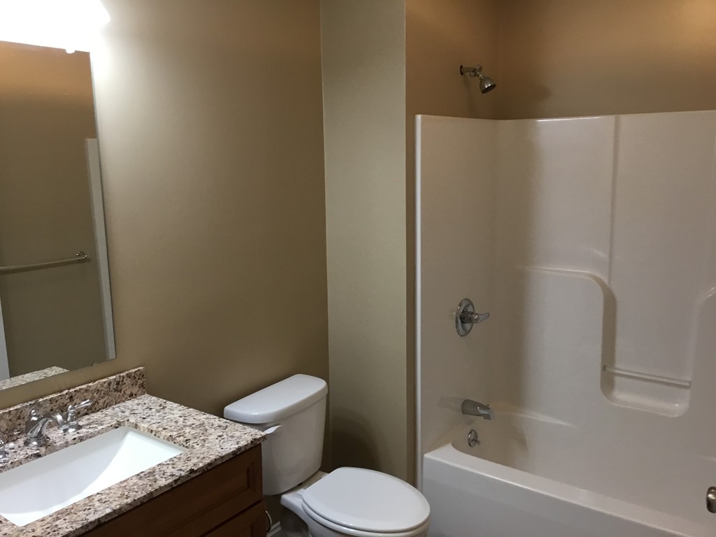 85 B Maple Avenue, Unit B Rutland, MA 01543 - Photo 16 of 19 a bathroom with a granite countertop sink toilet and shower