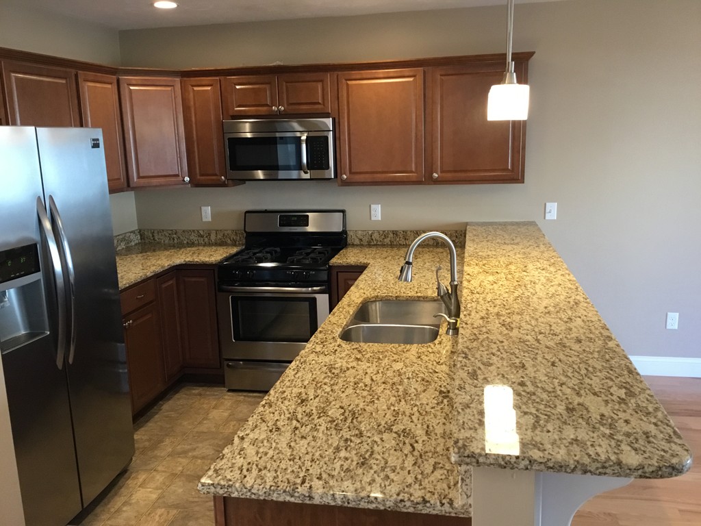85 B Maple Avenue, Unit B Rutland, MA 01543 - Photo 4 of 19 a kitchen with granite countertop a refrigerator stove and microwave