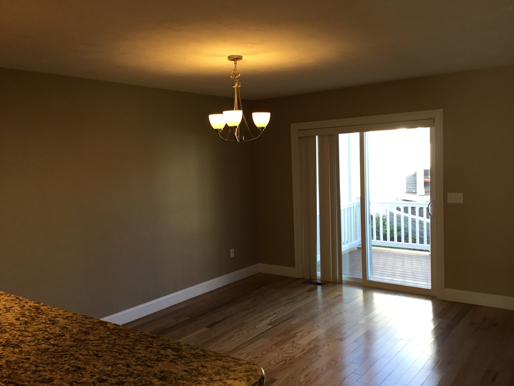 85 B Maple Avenue, Unit B Rutland, MA 01543 - Photo 5 of 19 an empty room with wooden floor and windows
