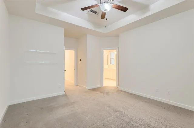 an empty room with a window and a ceiling fan