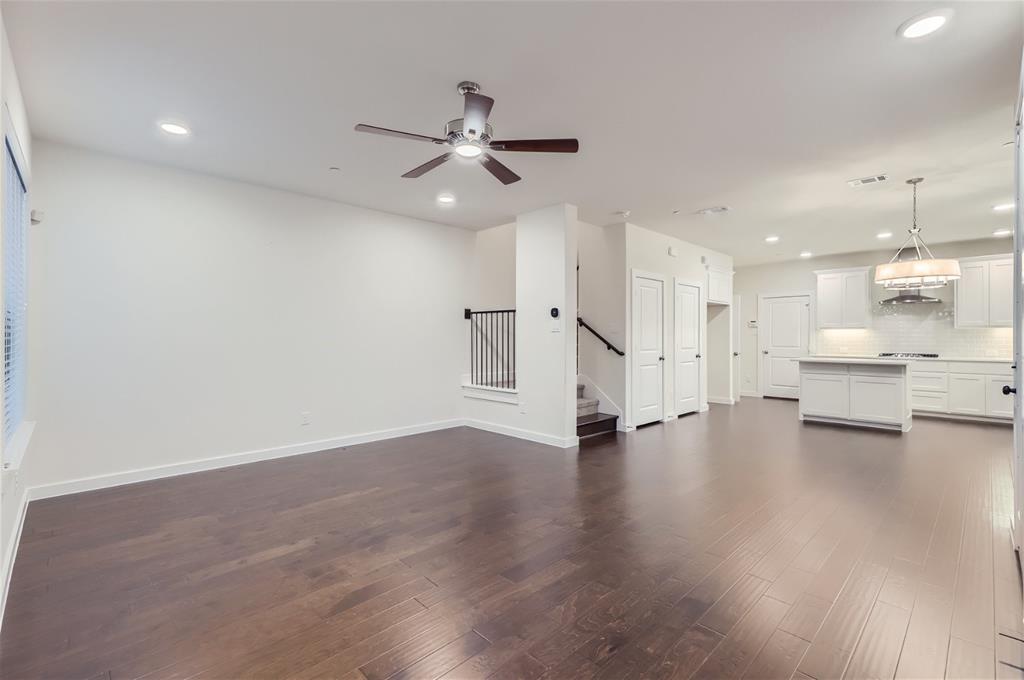 401 Division Street Plano, TX 75075 - Photo 7 of 28 a view of an empty room with wooden floor and a ceiling fan