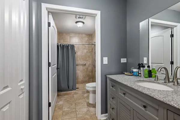 a bathroom with a granite countertop sink toilet and shower