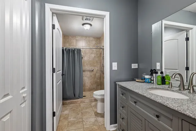a bathroom with a granite countertop sink toilet and shower
