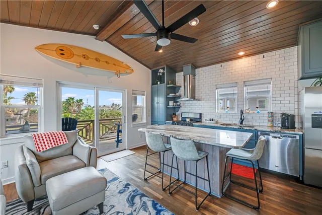 a kitchen with stainless steel appliances granite countertop a stove a sink dishwasher and cabinets with wooden floor