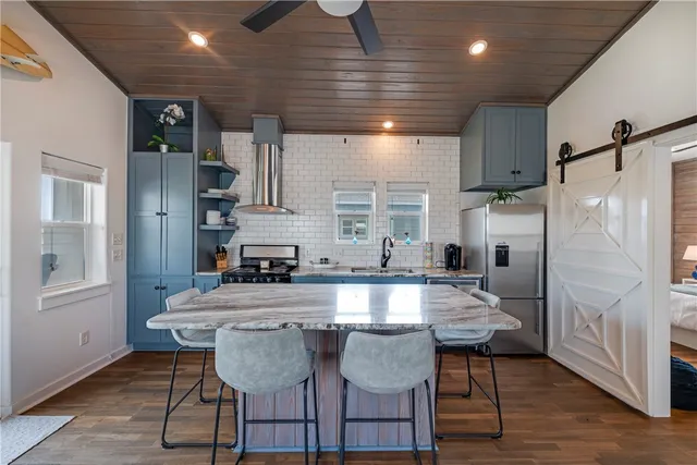 a large kitchen with a table chairs refrigerator and microwave