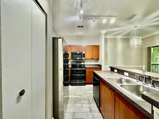 a large kitchen with stainless steel appliances granite countertop a sink and cabinets